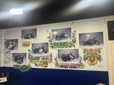 many pictures of motorcycles on the wall in this room