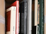 many books in a cardboard box on a white surface