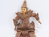une figurine représentant une personne assise sur une surface blanche