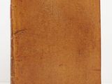 an old book sitting on top of a table next to a white wall