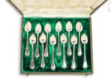 six spoons in a box with a green velvet lining