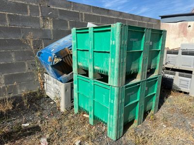 a pile of green crates sitting in a yard