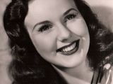 an old black and white photo of a woman with a smile on her face