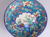 a blue bowl with a picture of a bird and flowers on it