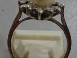 an image of a ring with a pearl and diamonds on top of it