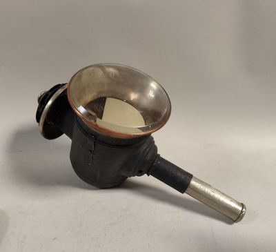 une petite casserole en métal avec une poignée, posée sur une surface blanche