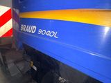 a blue and yellow train that is parked next to a red and white stripe