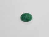 a close up of a green jade stone on a white surface