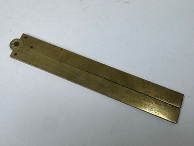 a close up of a brass plate on a white surface