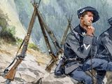 two men sitting on a rock in the mountains