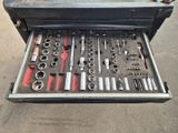 une boîte à outils remplie d'outils, posée par terre