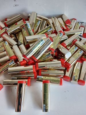 a pile of red and silver lipsticks on a white surface