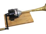 a brass trumpet on a wooden stand with a brass horn