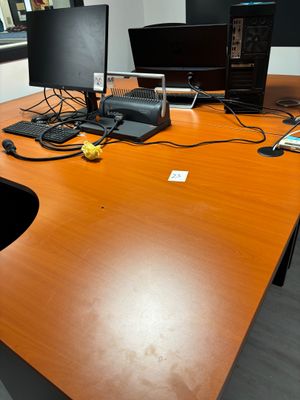 une image représentant un bureau avec deux ordinateurs et un téléphone portable