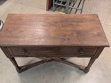 a small wooden table with a drawer on top of it