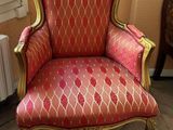 a red and gold chair in the corner of a room