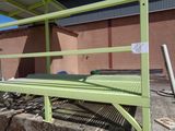 a green bench that is sitting on the side of a building