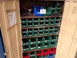 a large storage cabinet with many green bins in it
