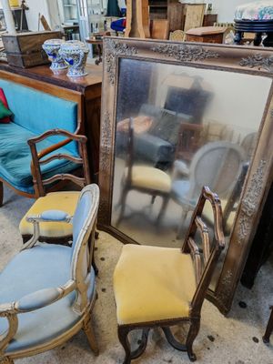 un grand miroir posé par terre à côté d'un canapé bleu