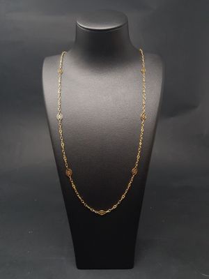 un collier à chaîne en or sur un mannequin, sur fond noir