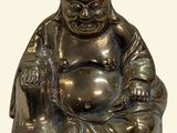 a statue of a laughing buddha sitting on the ground