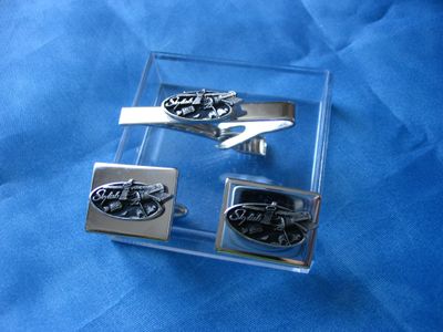 des boutons de manchette et une pince à cravate en argent, ornés du logo Ford