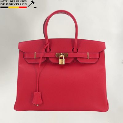 un sac à main en cuir rouge muni d'un cadenas sur la poignée