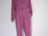 purple jumpsuit on a mannequin stand against a white wall