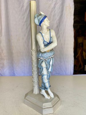 une figurine représentant un homme tenant une perche, posée sur une table