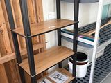 une étagère avec des tablettes et un seau posé par terre