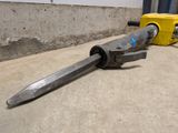 a hammer that is laying on the ground next to a yellow machine