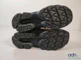 the soles of a pair of black hiking shoes on a white surface