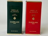 two boxes of perfume sitting next to each other on a white surface