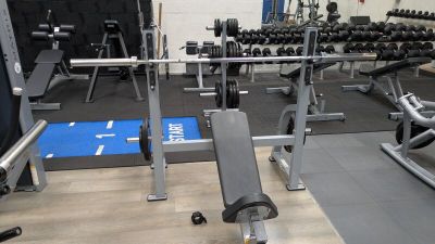 an image of a gym room with a bench and weights