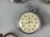 many different types of pocket watches on the table