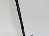 a close up of a black and gold golf club on a white surface