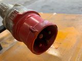 a close up of a red electrical plug on a yellow table