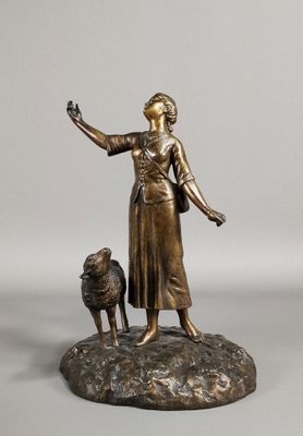 bronze statue of a woman with a dog on a rock