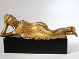 statue en bronze représentant une femme allongée sur un socle noir