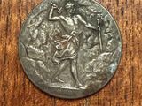 a close up of a silver coin on a wooden surface