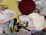 a pile of clothes and a pillow on a bed