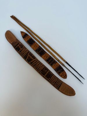 deux baguettes en bois et une paire de baguettes posées sur une surface blanche