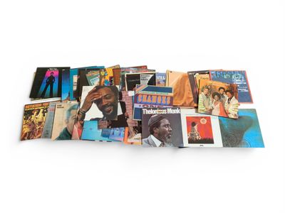 une vaste collection d'albums et de CD de toutes sortes posés sur une surface blanche