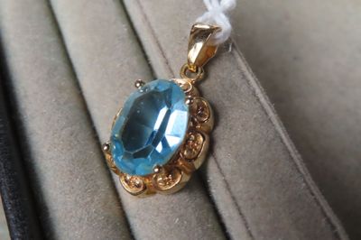 Pendentif en or jaune (750/1000e) orné d'une pierre bleue co…