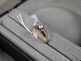 a diamond ring in a ring box with a ribbon around it