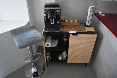 une petite cuisine équipée d'une cafetière et d'un tabouret de bar