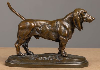 bronze statue of a dog standing on a base on a table