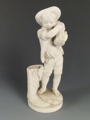statue représentant un garçon tenant un panier de fruits sur une souche