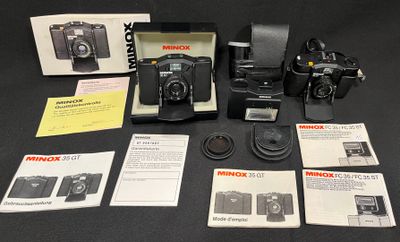 une boîte contenant des appareils photo et d'autres objets posée sur une table