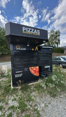 a sign that says pizzas on the side of the road